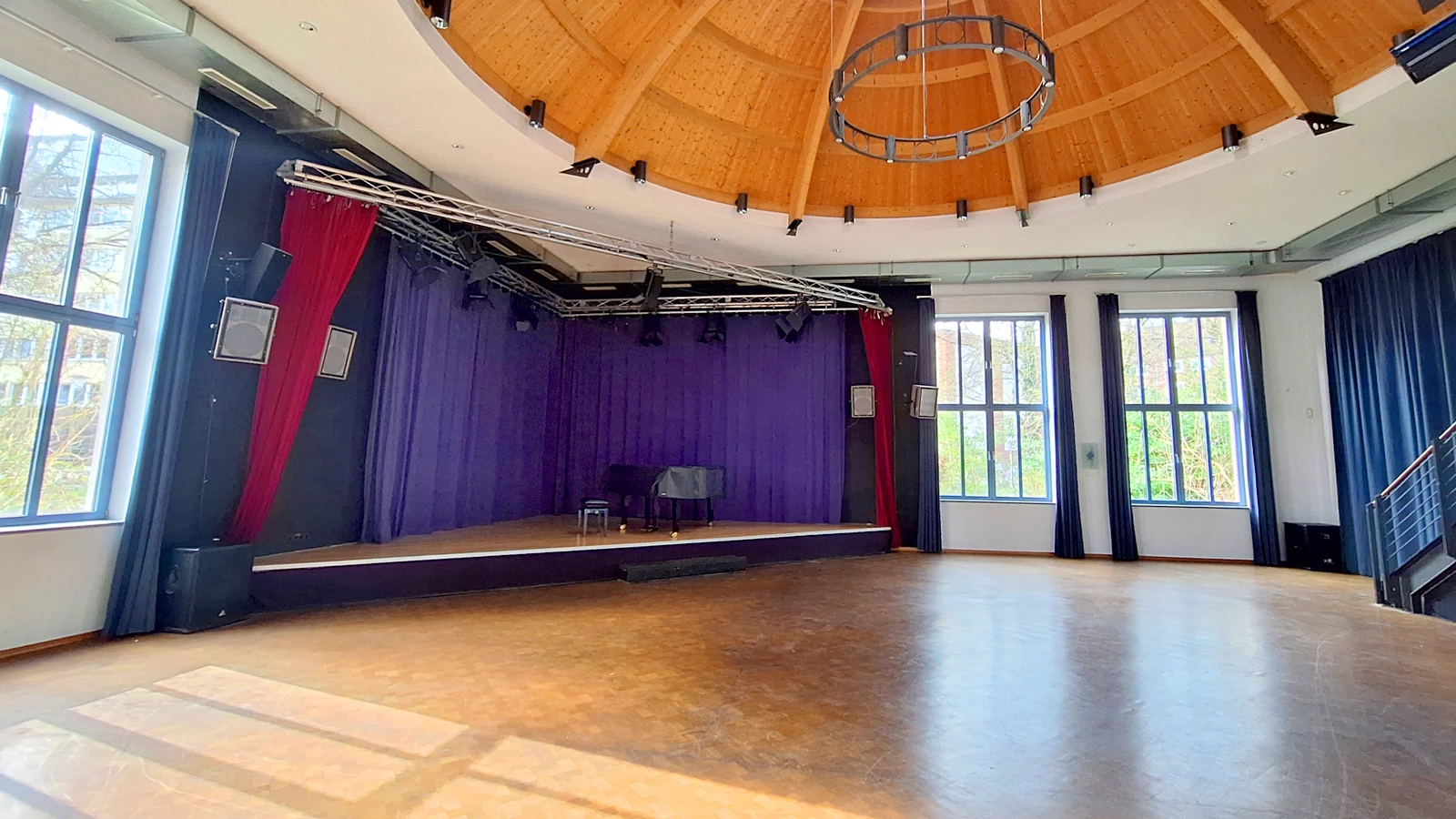 Der Kuppelsaal des B-Treff mit der Bühne, auf dem ein schwarzer Flügel steht