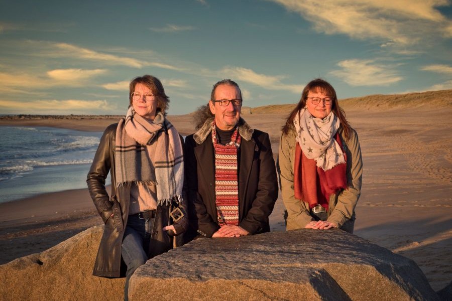 Das Trio Farvenspeel posiert vor der Nordsee