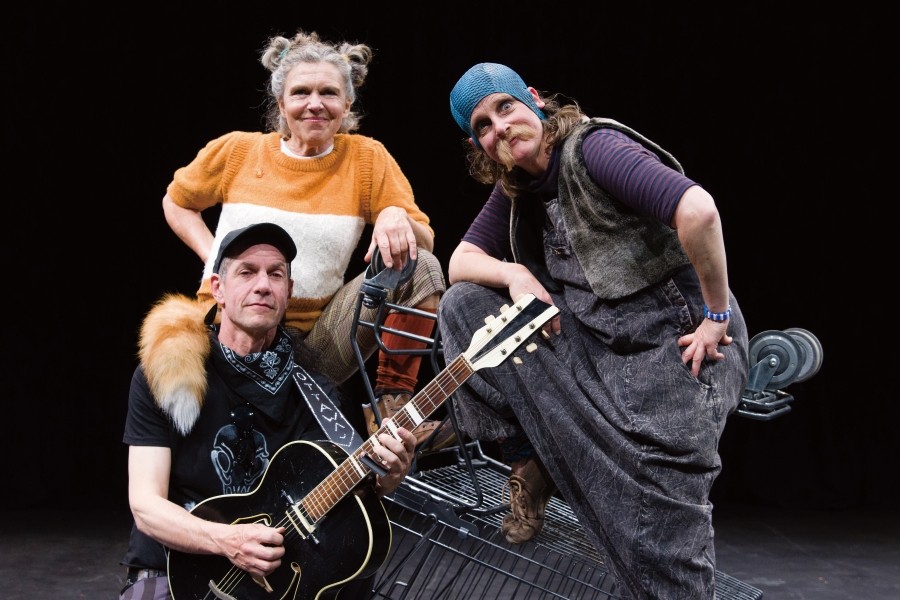 Die drei Schauspieleden posieren als Fuchs, Otter und Krähe. Die Krähe hält eine Gitarre in den Händen.